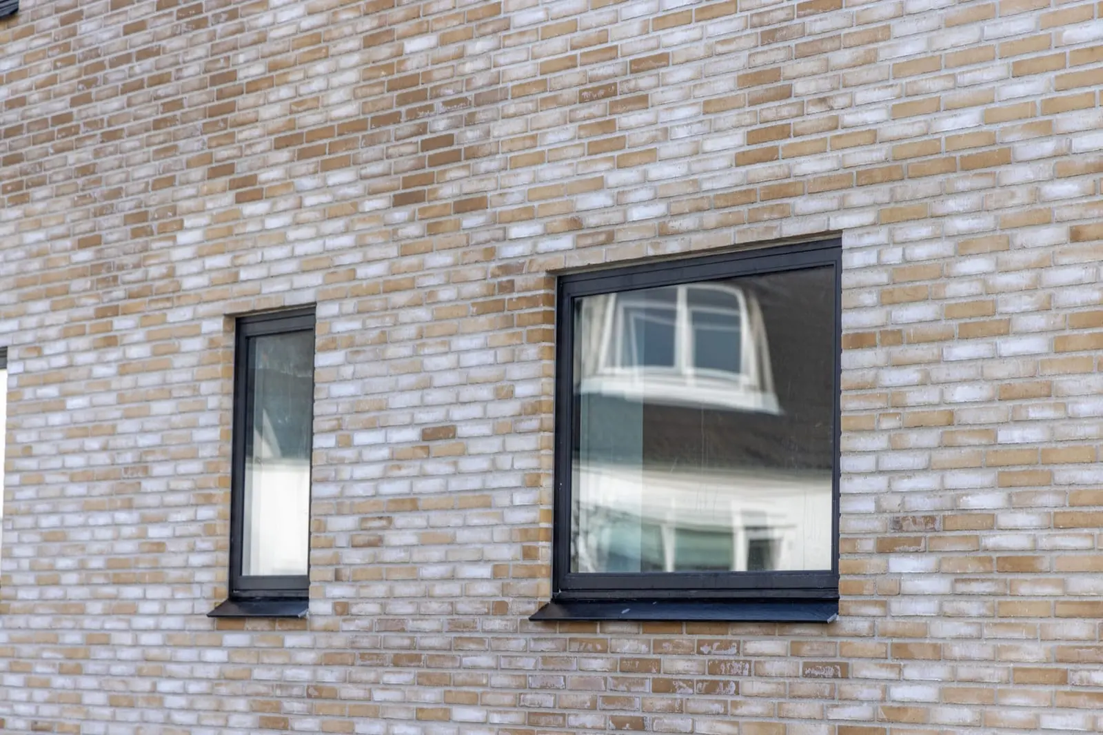 Murstensfacade med to sorte vinduer