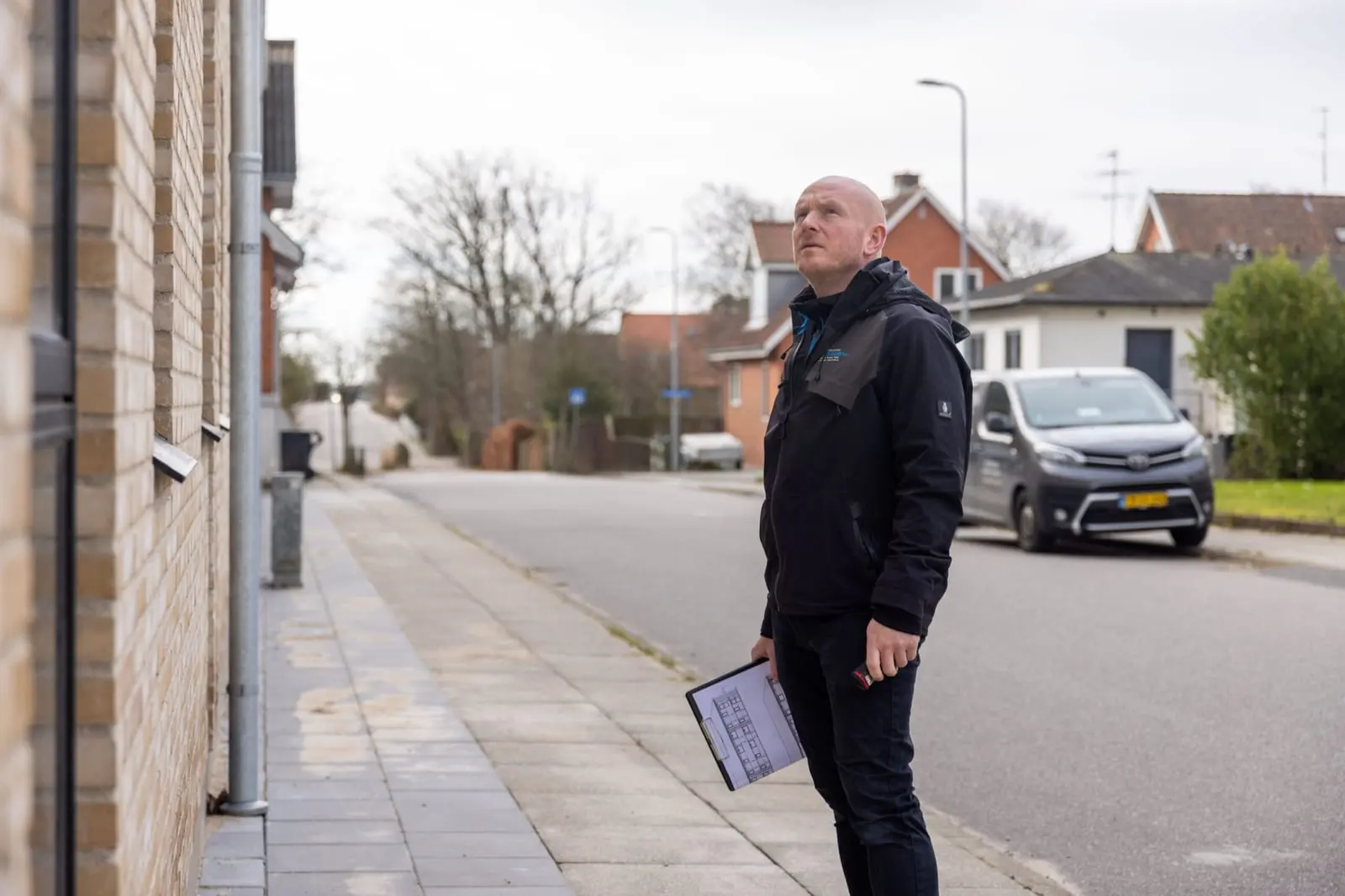 Byggesagkyndig efterser et murstenshus på en villavej