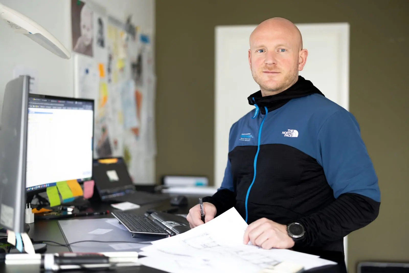 Byggesagkyndig arbejder med tegninger ved computeren
